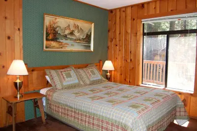 a bedroom with a bed and a picture on the wall at Burke's Place in Wawona