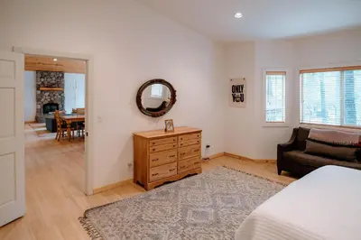 a bedroom with a bed and a dresser and a mirror at Beautiful and Spacious Home - Walk to Lake & Beach in Tahoma