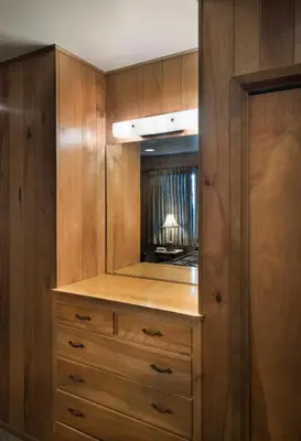 a closet with wooden cabinets and a mirror at Arnetts' Cabin in Wawona