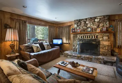 a living room with a couch and a fireplace at Arnetts' Cabin in Wawona