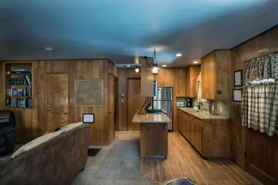 a kitchen with wooden cabinets and a couch in a room at Arnetts' Cabin in Wawona
