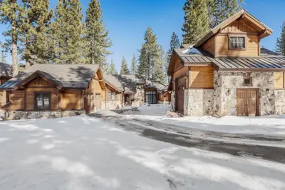 a snowy road in front of a log house at 4BR Cabin with Hot Tub – Ultimate Truckee Escape cabin in Truckee