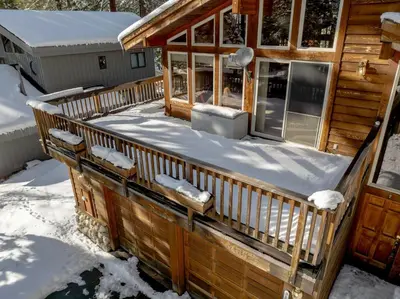 a deck of a log cabin in the snow at Handcrafted Tahoe Retreat Walk to Beach & Ski in Tahoe City