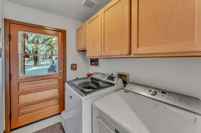 a small kitchen with a washing machine and a window at Handcrafted Tahoe Retreat Walk to Beach & Ski in Tahoe City