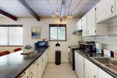 a kitchen with white cabinets and black counter tops at Sioux Serenity in South Lake Tahoe