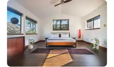 a large living room with a bed and windows at Alta Peak House in Three Rivers