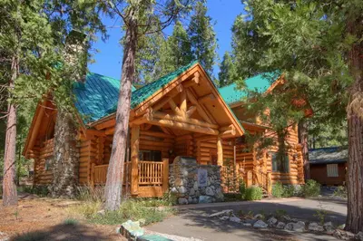 a log cabin with a green roof at Yosemite's Luxury Estate at The Redwoods in Yosemite 2349 in Wawona