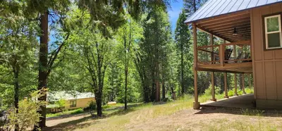 a house in the woods with a porch at Yosemite's Meadow Haven 2358 in Wawona