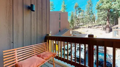 a wooden bench on a balcony with a view at Walk to Canyon Lodge Ski back Modern Space in Mammoth Lakes