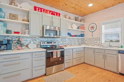 a kitchen with white cabinets and a stove at Why Knot Relax - Heated PRIVATE Pool Beach Gear Credit Included in Fresno