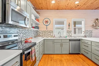 a kitchen with white cabinets and a wooden ceiling at Why Knot Relax - Heated PRIVATE Pool Beach Gear Credit Included in Fresno