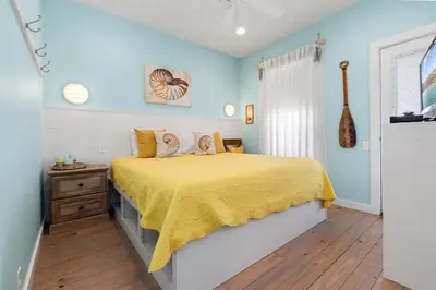 a bedroom with a bed with a yellow bedspread at Mermaid Cove PA - Beach Gear Credit Included in Fresno