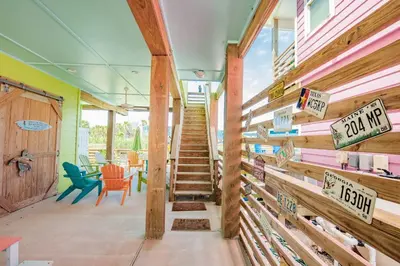 a staircase in a house with signs on the wall at Mermaid Cove PA - Beach Gear Credit Included in Fresno
