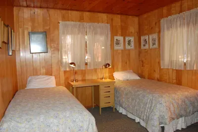 a bedroom with two beds and a desk with a window at Cozy 2Br Retreat with Scenic Deck & Outdoor Dining in Wawona