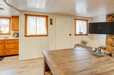 a living room with a wooden table and a kitchen at Walk to Beach Dog-Friendly Cabin in Glenbrook! in Glenbrook