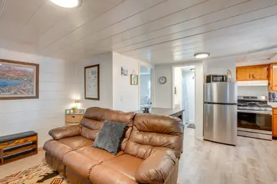 a living room with a leather couch and a kitchen at Walk to Beach Dog-Friendly Cabin in Glenbrook! in Glenbrook