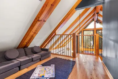 a living room with a couch and a table at Remodeled 4BDR Cabin with AC Lake Views Hot-Tub Bunk Room Excellent Location in Kings Beach