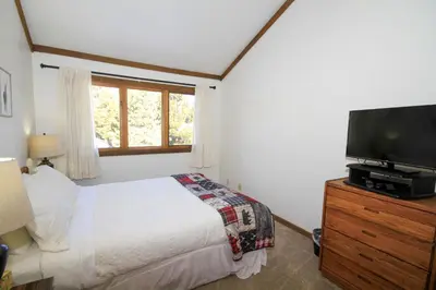a bedroom with a bed and a flat screen tv at Mountainback 19 Loft Den in Mammoth Lakes
