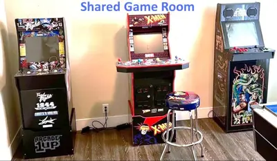 a arcade game room with a gaming machine and a stool at Cozy Tower Hideaway in Fresno
