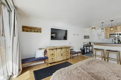 a living room with a table and a kitchen at Snowpeak Serenity in Truckee