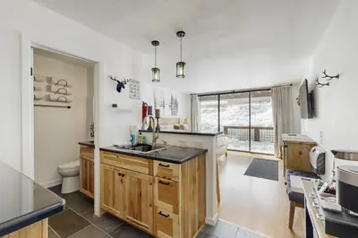 a kitchen with white walls and wooden cabinets at Snowpeak Serenity in Truckee