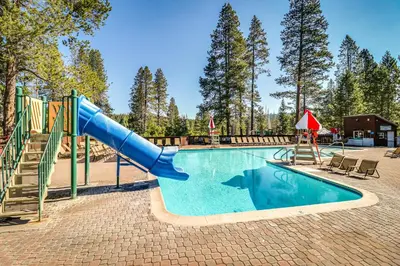 a swimming pool with a slide and a playground at Snowpeak Serenity in Truckee