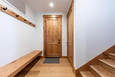 a hallway with a wooden door and stairs at Radiant Retreat by Tahoe Getaways - 4 BR in Tahoe Donner with Hot Tub & HOA in Truckee
