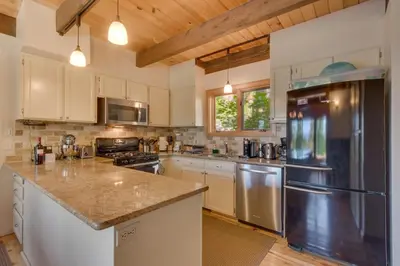 a kitchen with white cabinets and a stainless steel refrigerator at Hyphen 3-bedrooms rental, private beach, filtered view in Tahoe City