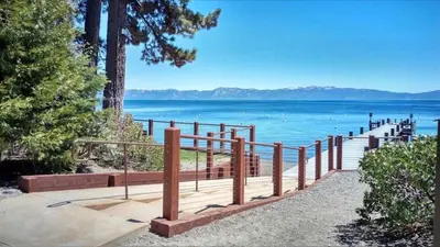 a wooden walkway leading to a beach with the water at Hyphen 3-bedrooms rental, private beach, filtered view in Tahoe City