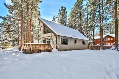 a house in the snow in the woods at Bear Chalet - Snow Play - 4 Bedrooms - Foosball in South Lake Tahoe