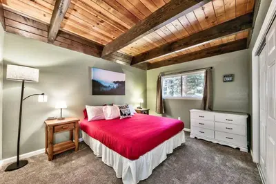 a bedroom with a large bed with a red bedspread at Bear Chalet - Snow Play - 4 Bedrooms - Foosball in South Lake Tahoe