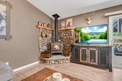 a living room with a fireplace and a tv at Great Cabin with AC Firepit Fireplace in Arnold