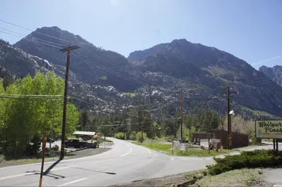 an empty road with mountains in the background at Whispering Pines in June Lake