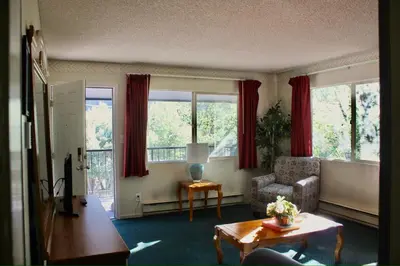 a living room with a couch and a chair and windows at Whispering Pines in June Lake