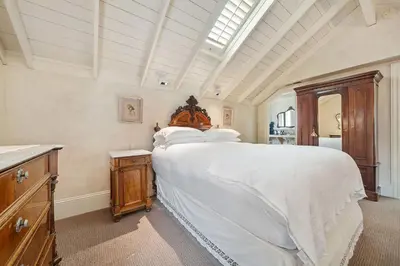 a bedroom with a large white bed and a wooden dresser at Brinnwood Bed & Breakfast in Sutter Creek