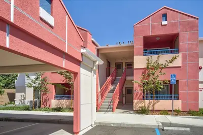 a red building with a staircase in front of a building at Orchard Parks in Tracy