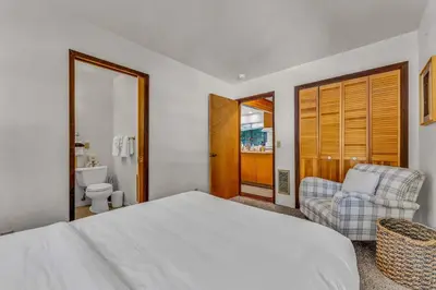a bedroom with a bed and a chair and a toilet at Cozy Carnelian Bay Escape with Deck and Foosball in Carnelian Bay