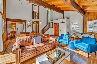 a living room with a leather couch and blue chairs at Cozy Carnelian Bay Escape with Deck and Foosball in Carnelian Bay
