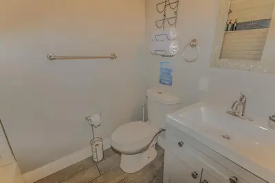 a white bathroom with a toilet and a sink at Reno Retreat 3 King Beds by Casinos and University in Reno