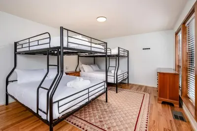 two bunk beds in a room with wooden floors at Spacious Mountain View Oasis - Pool, Spa & Game Rm in Oakhurst