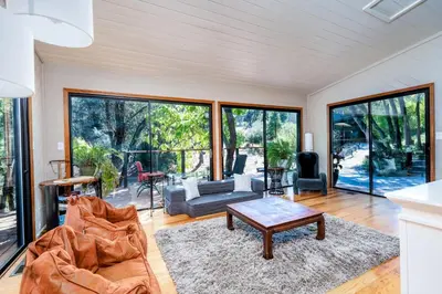 a living room with a couch and a table at Spacious Mountain View Oasis - Pool, Spa & Game Rm in Oakhurst