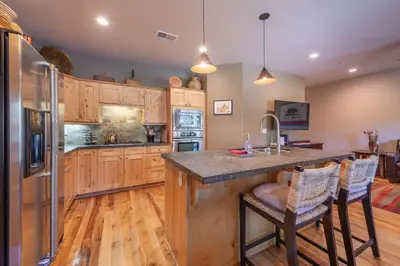 a kitchen with wooden cabinets and a island with bar stools at Deluxe Truckee Townhome 3BDR Dog Friendly Great Location in Truckee