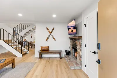 a living room with a fireplace and a staircase at Cozy Condo for 8 Hot-Tub HOA Amenities Walk to Beach Close to Slopes in Tahoe City