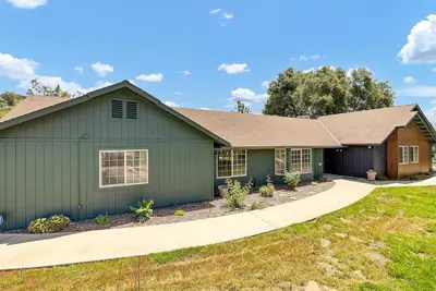 a green house with a driveway at Yosemite & Bass Lake 3 Acres, Pool, Game Room, Stunning Views in Coarsegold