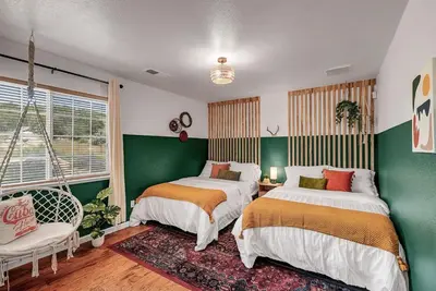 two beds in a room with green and white at Yosemite & Bass Lake 3 Acres, Pool, Game Room, Stunning Views in Coarsegold