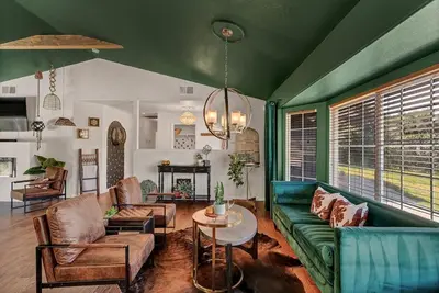 a living room with a green couch and a table at Yosemite & Bass Lake 3 Acres, Pool, Game Room, Stunning Views in Coarsegold