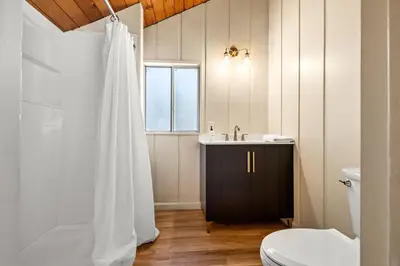 a bathroom with a white shower curtain and a sink at River Haus Sequoia | Hot Tub+New+King Beds+Views! in Springville