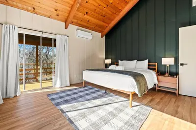 a bedroom with a bed and a green wall at River Haus Sequoia | Hot Tub+New+King Beds+Views! in Springville