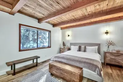 a bedroom with a large bed and a window at Cozy Cabin&HotTub Mins to N StarSki Sleeps 12 in Tahoe Vista