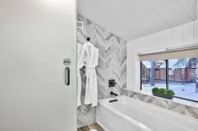 a white bath tub in a bathroom with a window at Cozy Cabin&HotTub Mins to N StarSki Sleeps 12 in Tahoe Vista